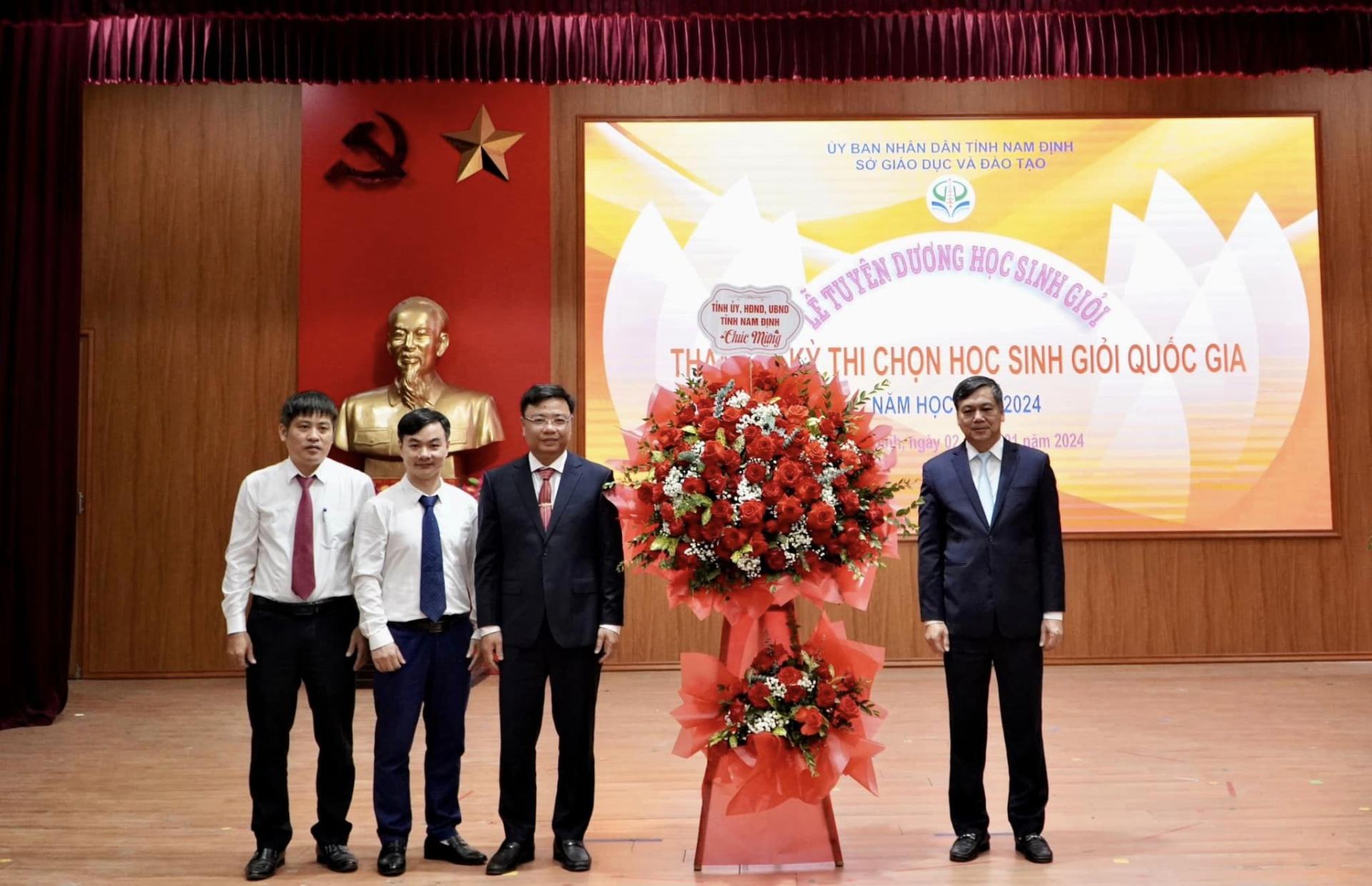 Đồng chí Trần Lê Đoài - Ủy viên BCH Tỉnh ủy, Phó Chủ tịch UBND tỉnh tặng hoa chúc mừng Lãnh đạo trường THPT chuyên Lê Hồng Phong, Nam Định